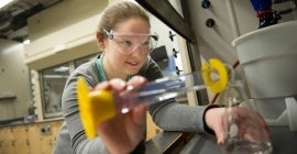 woman filling beaker in research lab